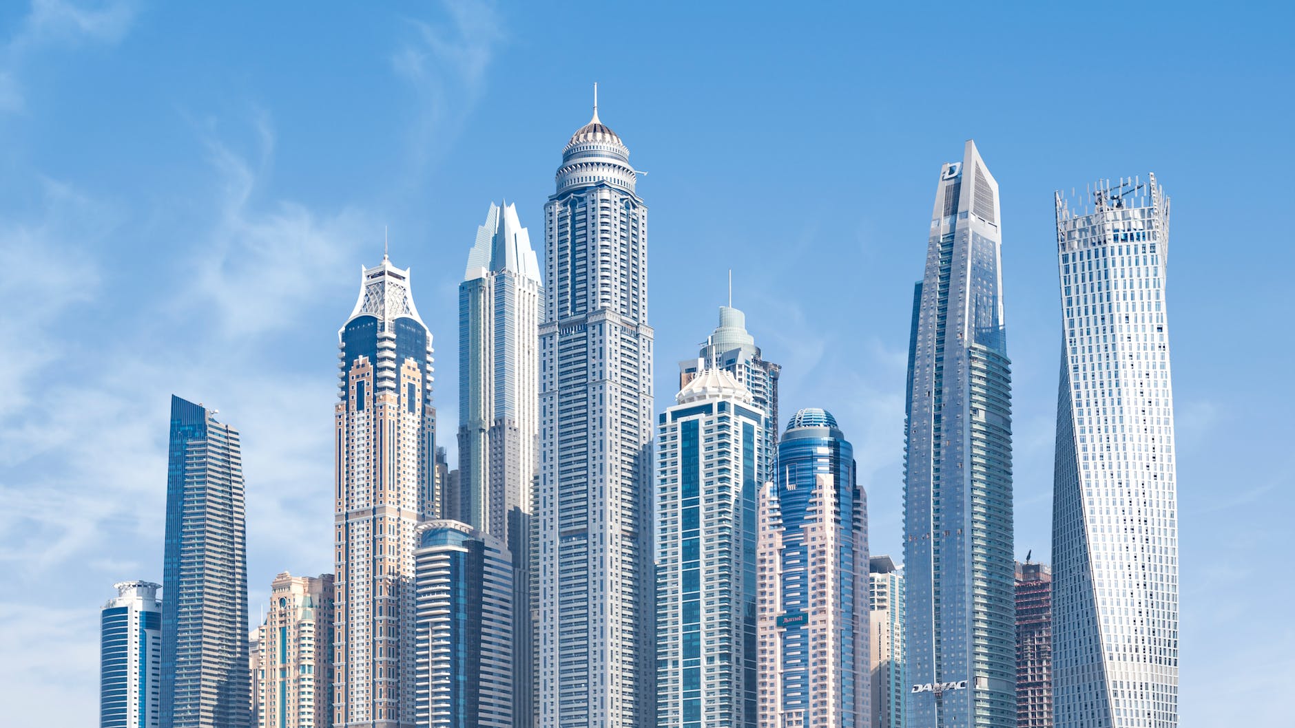 concrete high rise buildings under blue sky Dubai