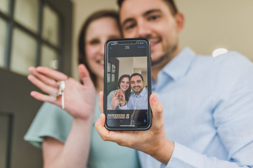 couple having group selfie while holding key